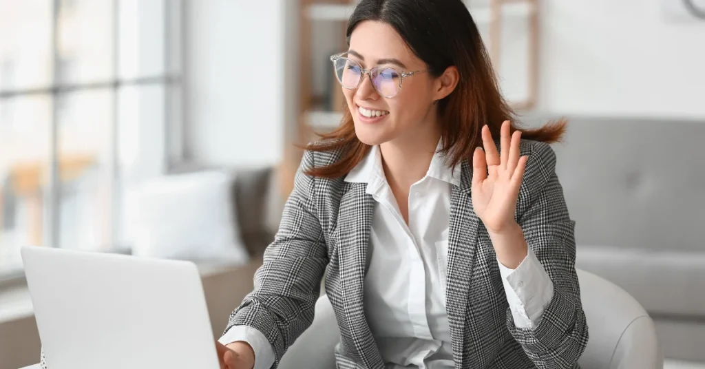 woman is greeting in front of laptop camera