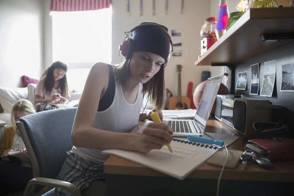 Student practicing English speaking skills using headphones and laptop